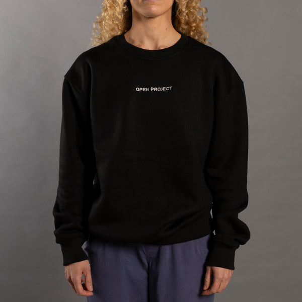 Woman wearing a black sweatshirt with 'OPEN PROJECT' text on a gray background
