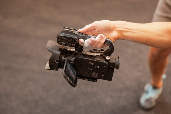 Person holding a video camera with a blurred background