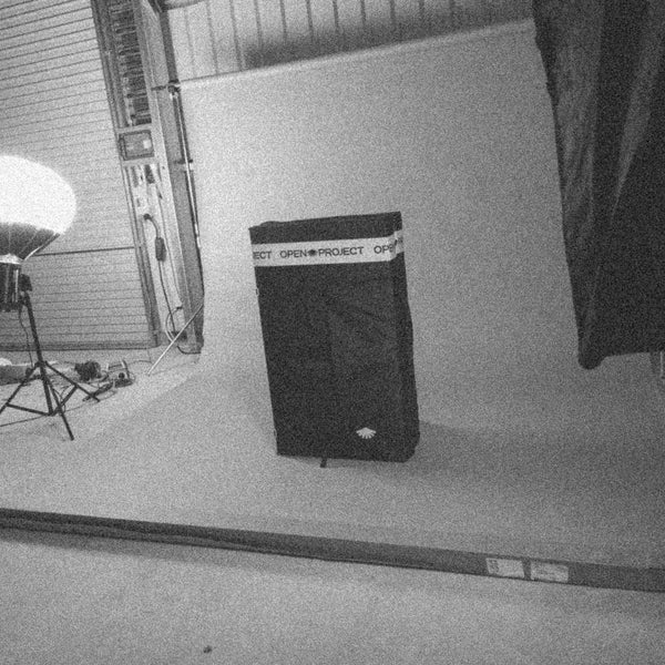 Black climbing pad a white floor with a light fixture in the background