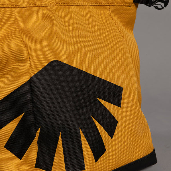 Close up of yellow boulder bag with black logo on front.