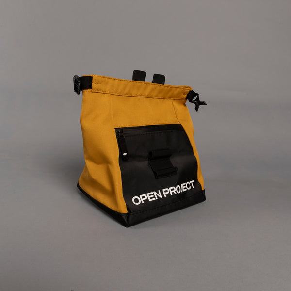Yellow and black boulder bag with 'Open Project' branding on a gray background