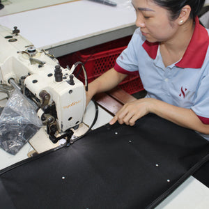 Person operating a sewing machine in a workshop setting