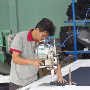 Person working on a sewing machine in an industrial setting