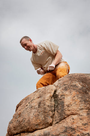 Man climbing a rock face with a clear sky background