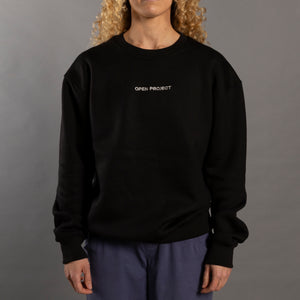 Woman wearing a black sweatshirt with 'OPEN PROJECT' text on a gray background