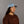 Person wearing a blue cap and brown 'Open Project' shirt against a gray background