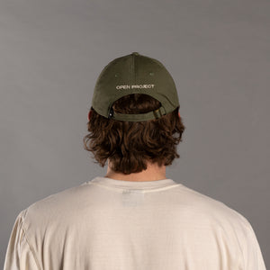 Person wearing a green cap with 'Open Project' branding on the back, against a gray background
