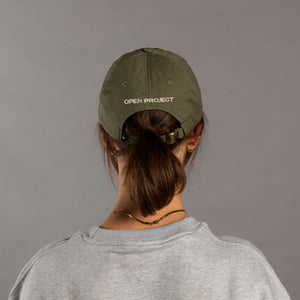 Person wearing a green cap with 'Open Project' logo on a gray background