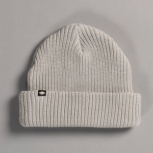 Gray knit beanie with a small logo on a gray background