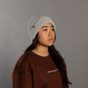 Person wearing a gray knit beanie and brown sweatshirt with 'Open Project' text on a gray background