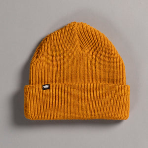 Mustard yellow knit beanie with a small logo on a gray background