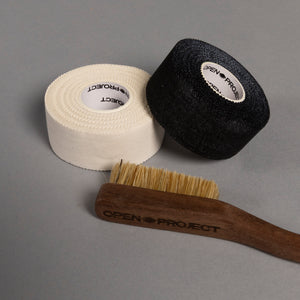 Two rolls of climbing tape and a brush with 'Open Project' branding on a gray background
