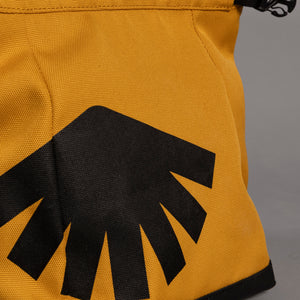 Close up of yellow boulder bag with black logo on front. 