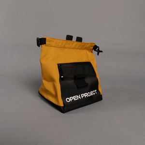 Yellow and black boulder bag with 'Open Project' branding on a gray background