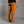 Person wearing mustard yellow climbing pants and beige shoes on a gray background
