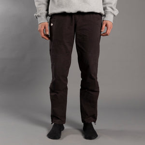 Man wearing charcoal climbing pants in front of grey background