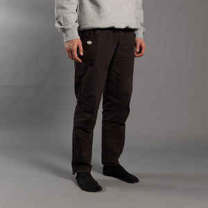 Person wearing dark climbing pants and a light gray sweatshirt on a plain background