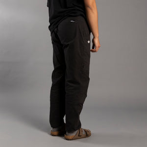 Person wearing black climbing pants on a gray background