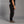 Person wearing black climbing pants and sandals on a gray background