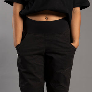 Person wearing black climbing pants with a neutral background