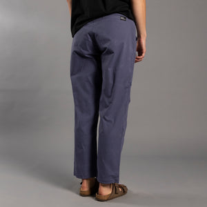 Person wearing blue climbing pants on a gray background