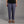 Person wearing purple climbing pants and brown sandals on a gray background