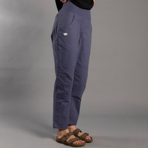 Person wearing blue climbing pants on a gray background