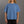 Person wearing a blue t-shirt with a logo on a gray background