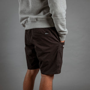 Person wearing black shorts and a gray sweatshirt on a gray background