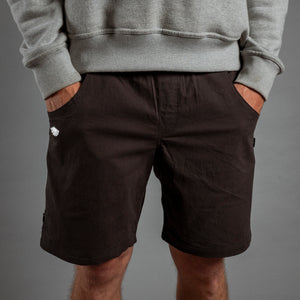 Person wearing black shorts and a gray sweatshirt on a gray background