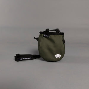 Green chalk bag with a strap on a gray background