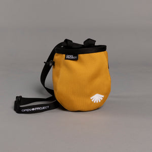 Yellow chalk bag with black strap and 'Open Project' branding on a gray background