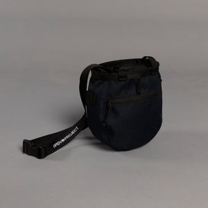 Navy bag with a strap on a gray background